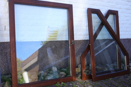 brown uPVC windows leaning against the wall of a house